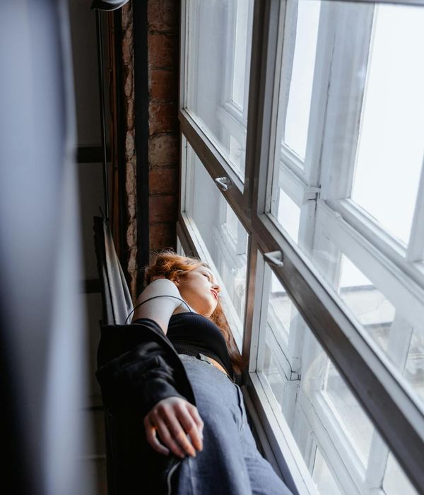 Woman feeling energetic and balanced in a bright, clean room.